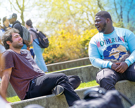 Two transfer students sitting on the Staller Center steps chatting