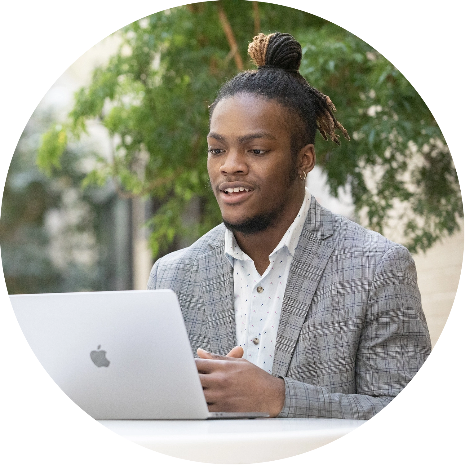 College of Business Online MBA Student on class via his laptop smiling and engaging in the virtual class