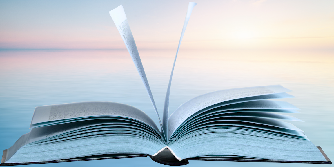 Image of an open book laying on a table pages with pages moving 