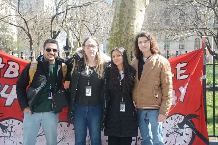 a group of four people pose together