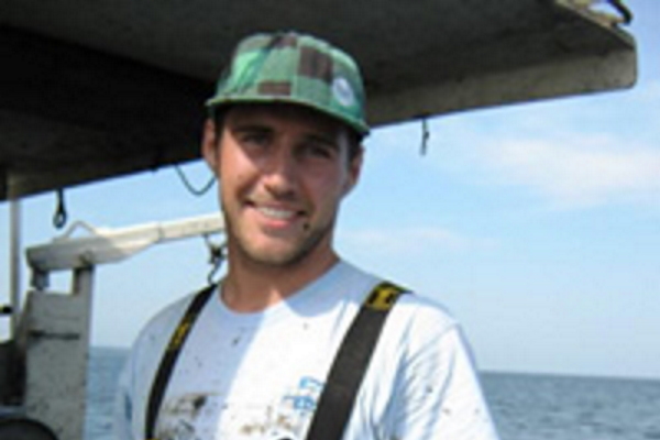 John Holden in waders onboard a boat