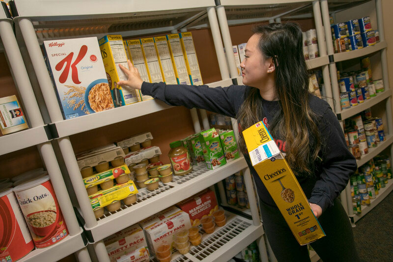 Student stocking shelves with grocery items