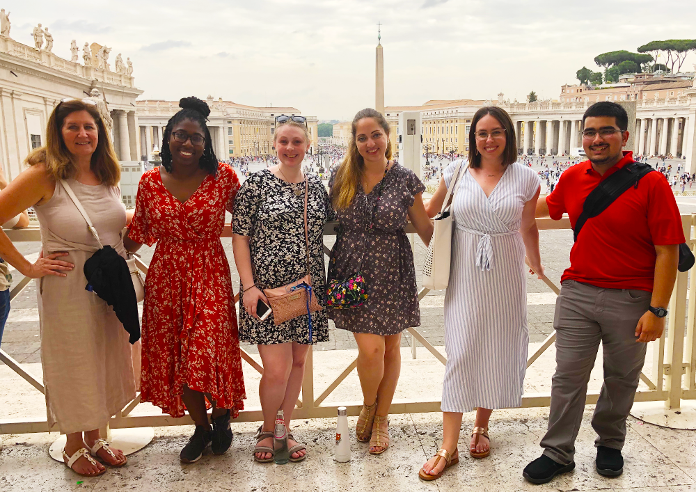 HEA students pose as a group in front of Italian landscape