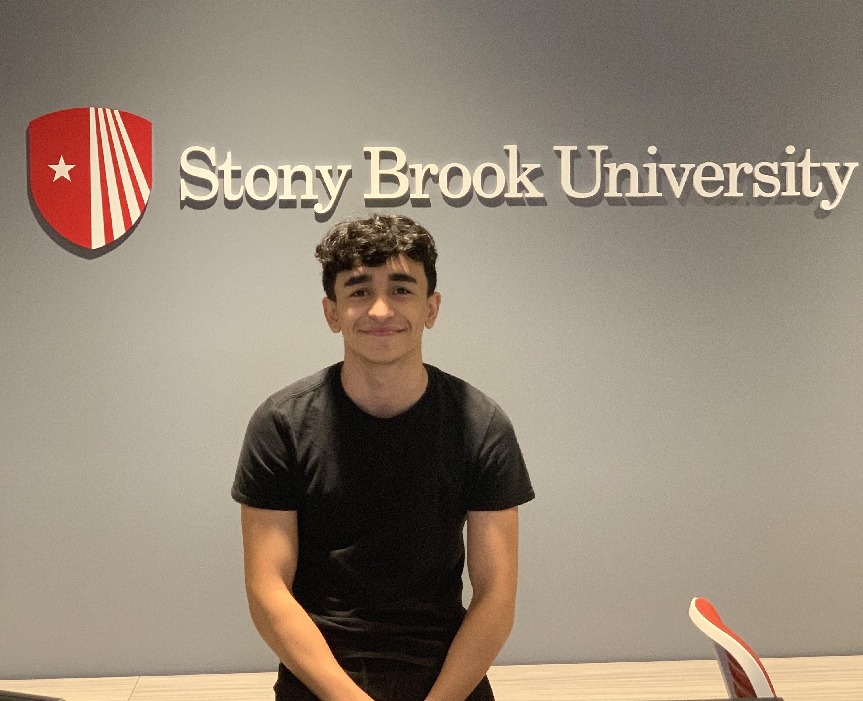 male student posing in front of wall